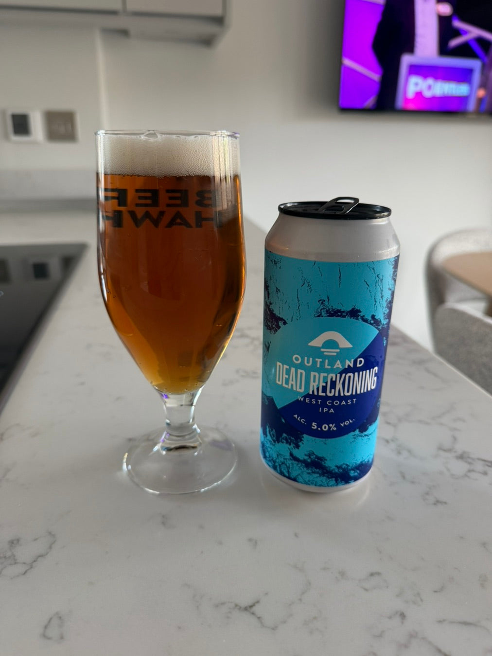 Glass of beer beside a can of Outland Dead Reckoning on a kitchen worktop