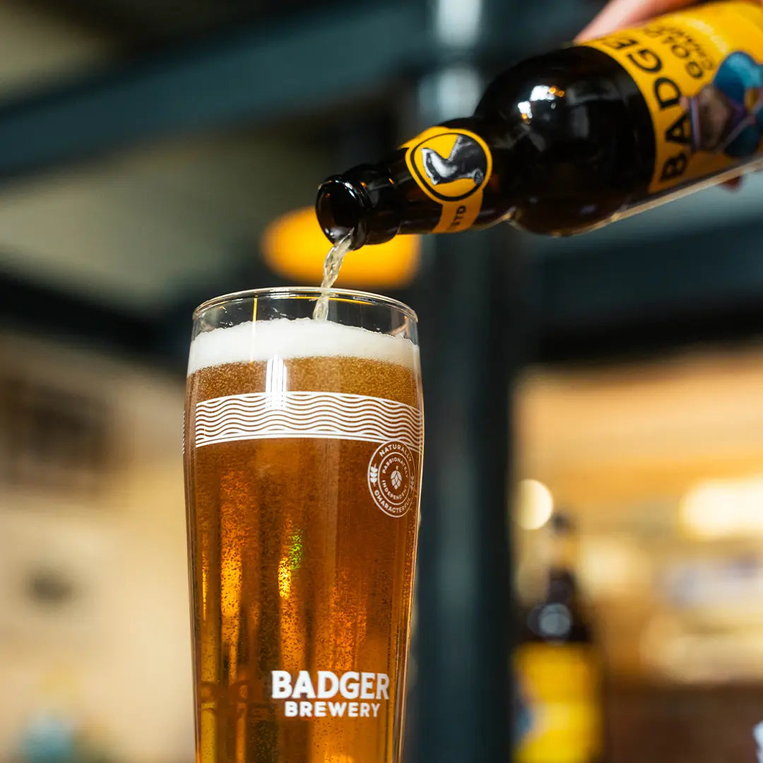 Badger Golden Champion poured from the bottle into a tall Badger pint glass