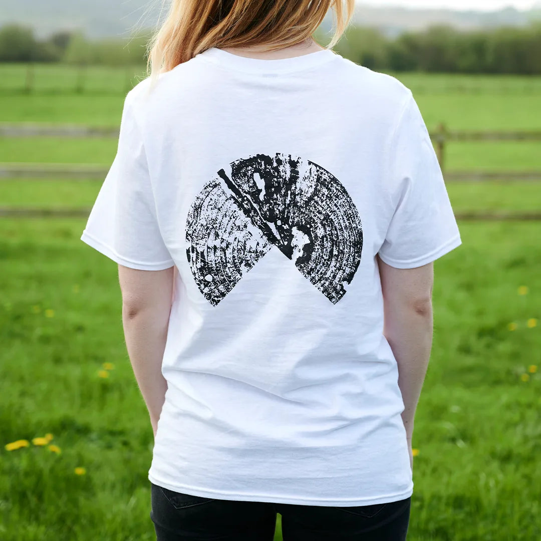 Back of the white Outland t-shirt worn outdoors, showing the black tree ring graphic