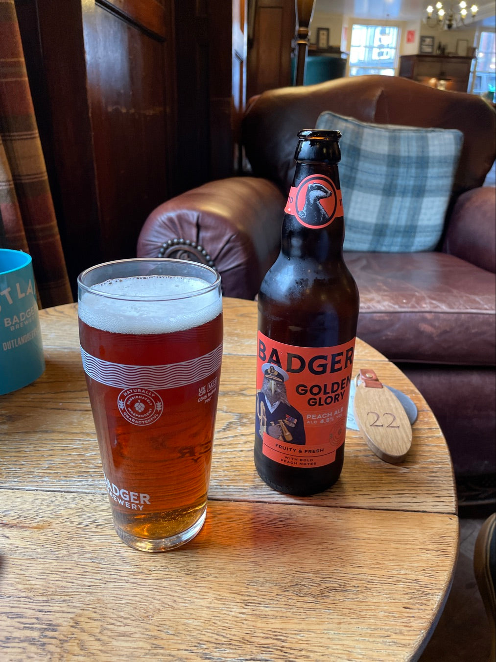 Pint and bottle of Badger Golden Champion on a table in a pub lounge