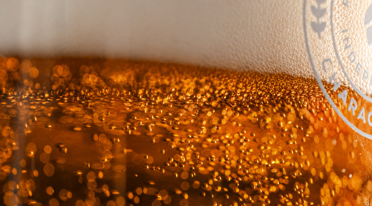 Close-up of beer bubbles rising in a branded Badger Brewery glass