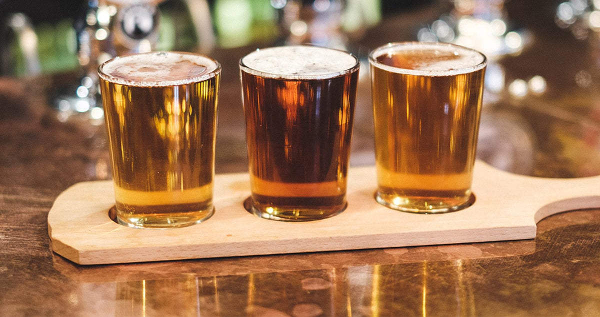 Flight of three Badger beer tasting glasses on a wooden paddle