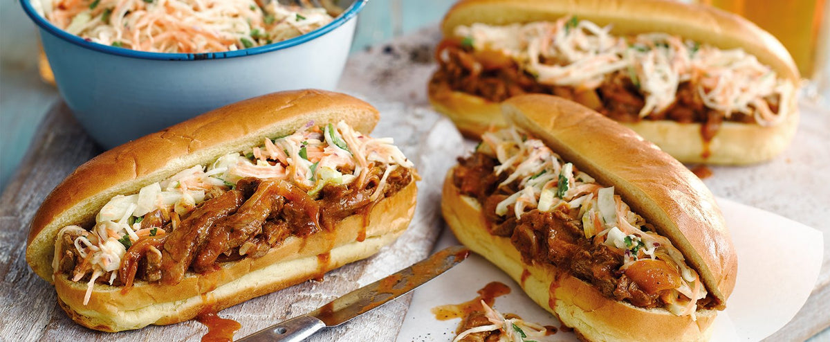 Two Fursty Ferret beef hot dogs with a bowl of homemade coleslaw