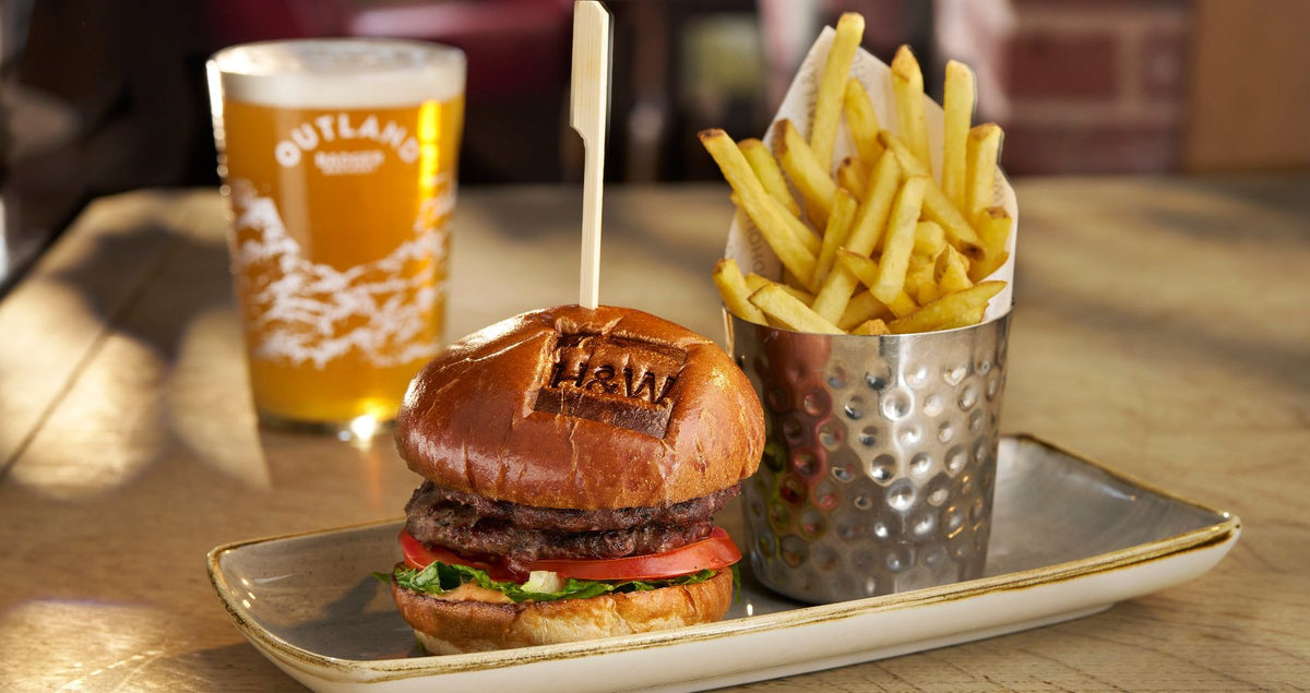 Hall & Woodhouse branded burger and fries with a pint of Outland
