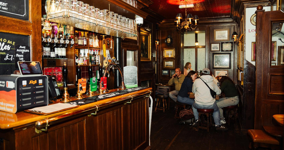 Interior bar of a Hall & Woodhouse London gastropub with bottles on the back shelf