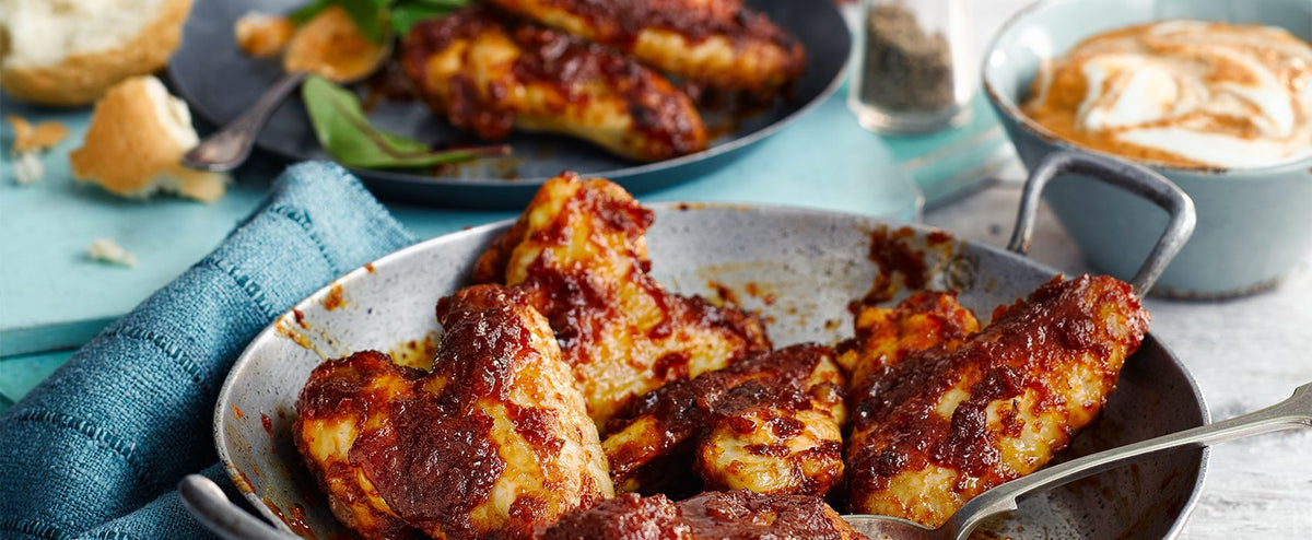 Sticky Cranborne Poacher chicken wings in a pan with a dip