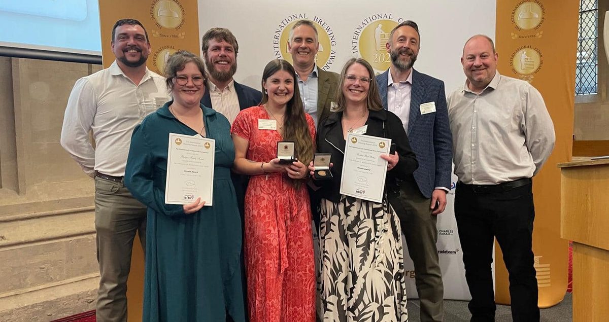 Hall & Woodhouse brewing team holding their International Brewing Awards certificates