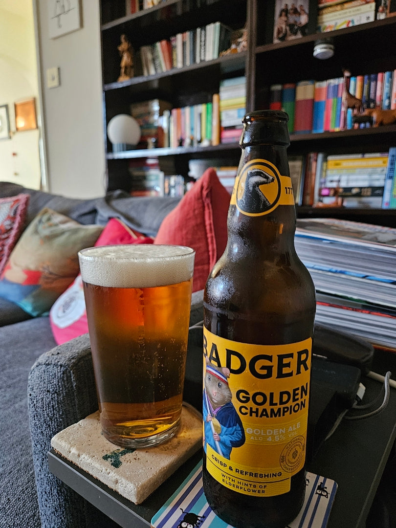 Bottle of Badger Golden Champion and a full pint on a side table at home