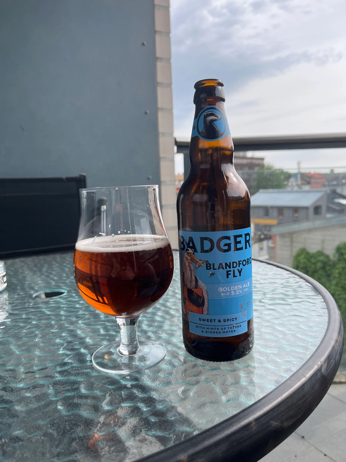 Bottle of Badger ale and a glass of beer on a balcony table