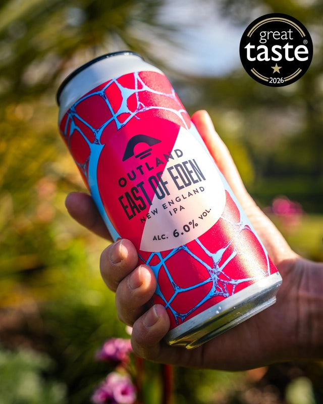 Hand holding a can of Outland East of Eden with a Great Taste award logo
