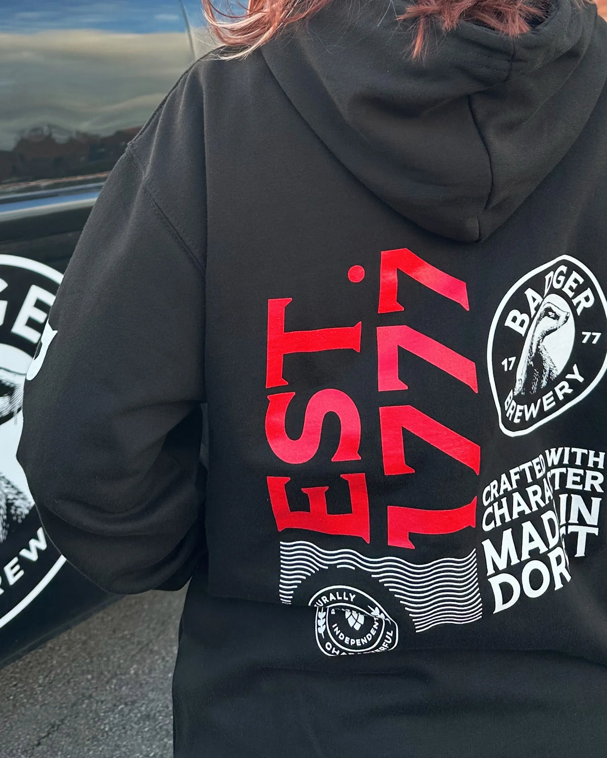 Back of the black Badger hoodie worn outdoors, showing the Est. 1777 Made in Dorset print
