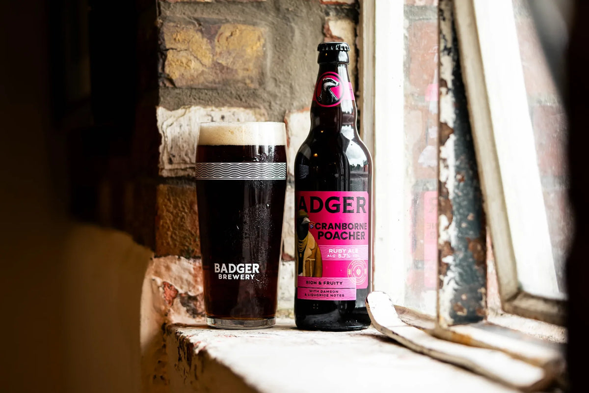 Bottle and glass of Cranborne Poacher ruby ale on a stone window ledge