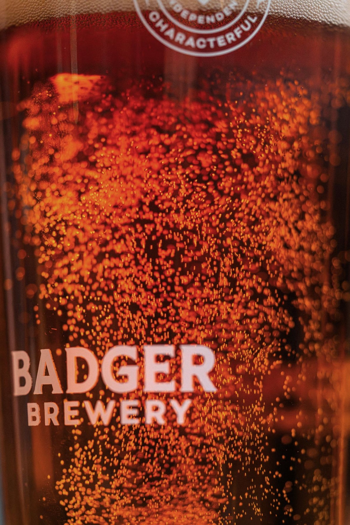 Close-up of a Badger Brewery pint glass filled with amber Fursty Ferret ale