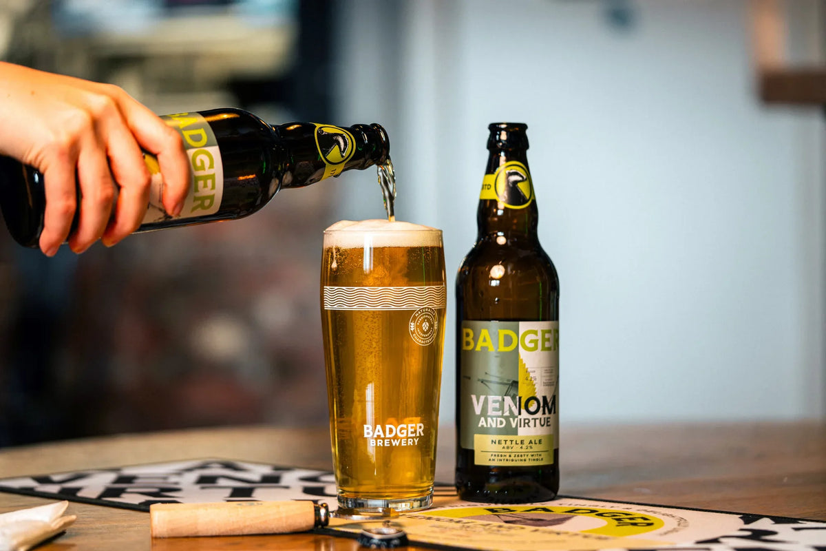 Venom and Virtue poured into a glass on a pub table beside a second bottle