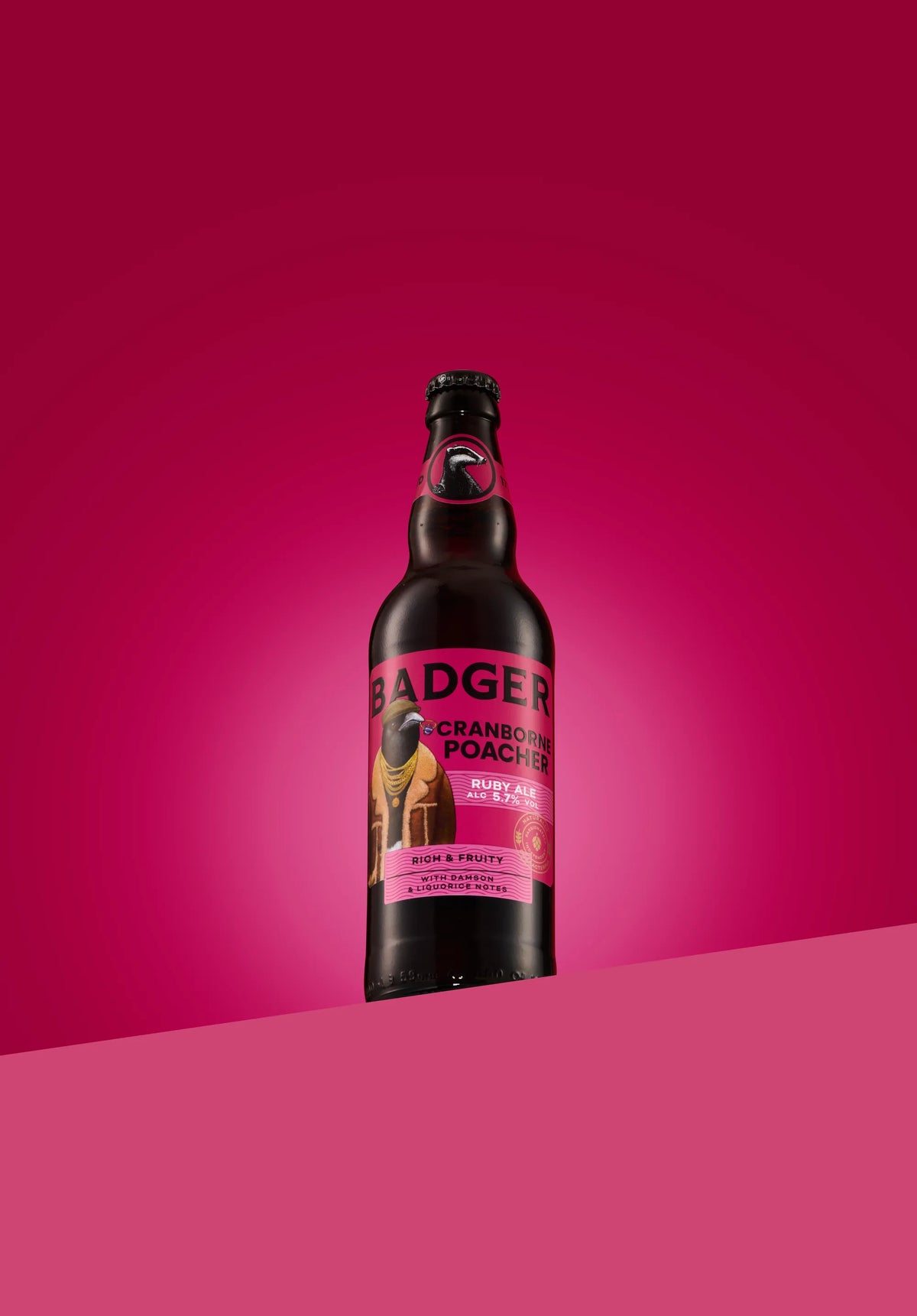 Bottle of Badger Cranborne Poacher ruby ale on a deep pink background