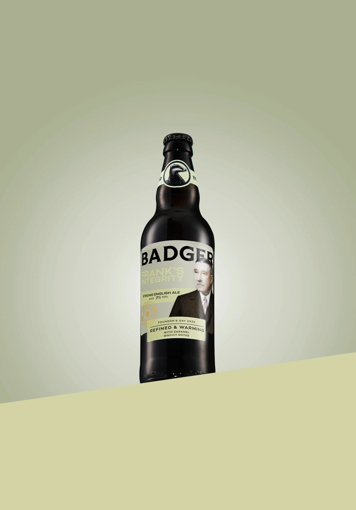 Bottle of Badger Frank's Integrity strong English ale on a pale olive background
