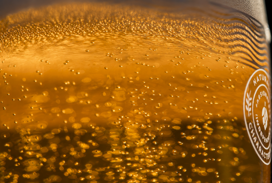 Close-up of golden ale filling a branded Badger glass, used for the golden ale collection