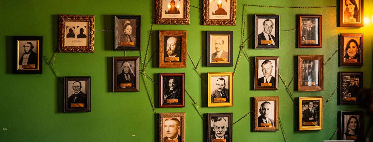 Wall of framed Hall & Woodhouse family portraits in the brewery heritage room