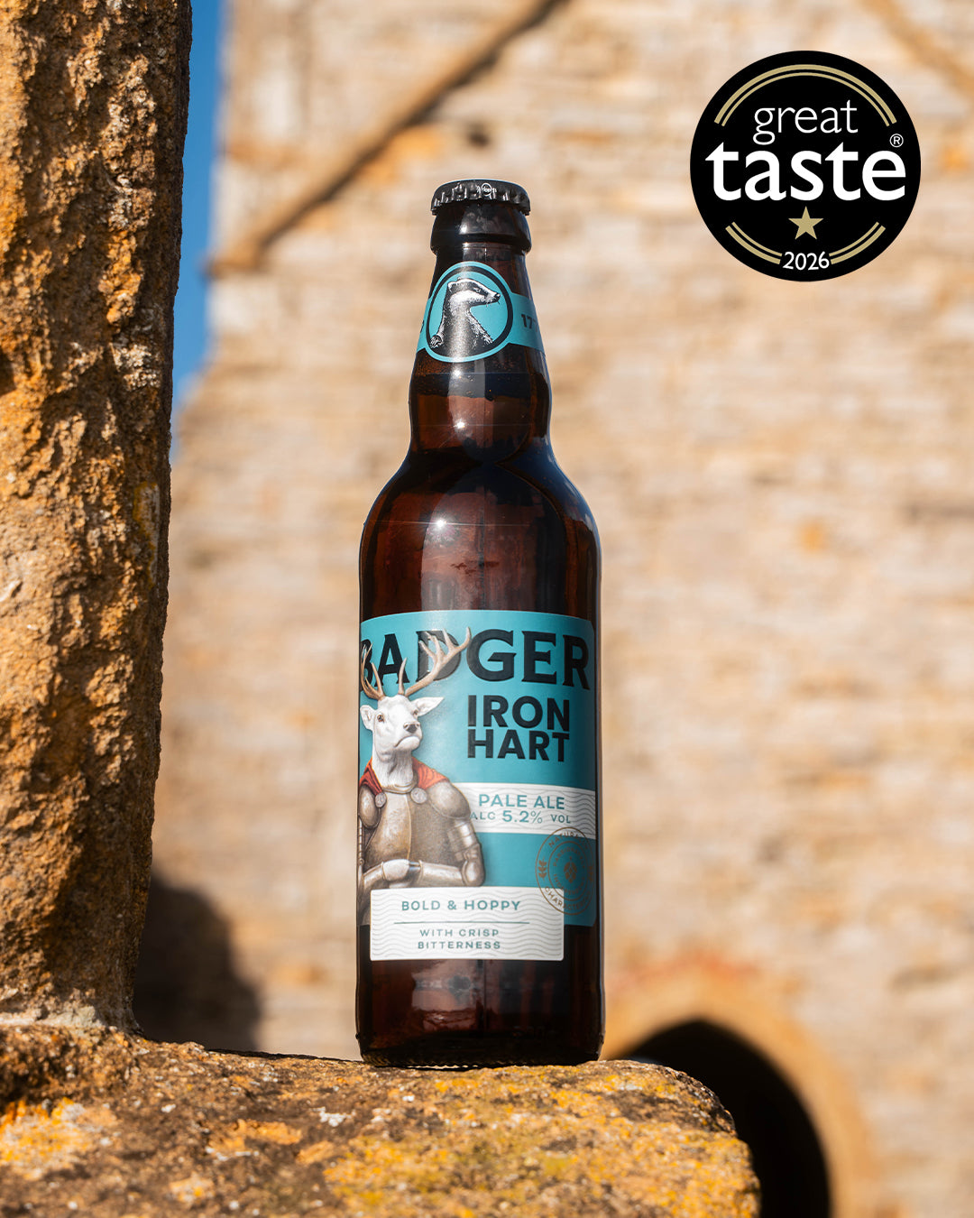 Bottle of Badger Iron Hart against a stone wall with a Great Taste award logo