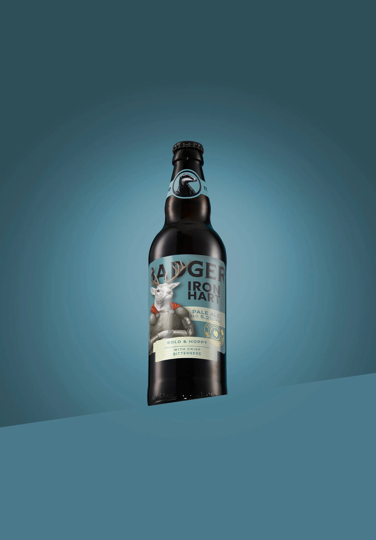Bottle of Badger Iron Hart pale ale on a teal background