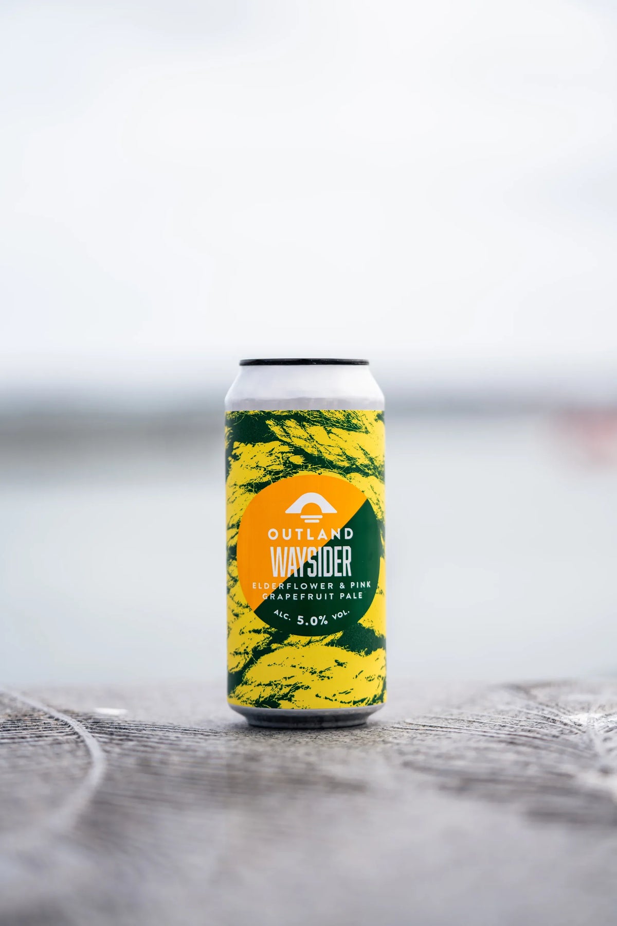 Can of Outland Waysider standing on a quayside with water behind