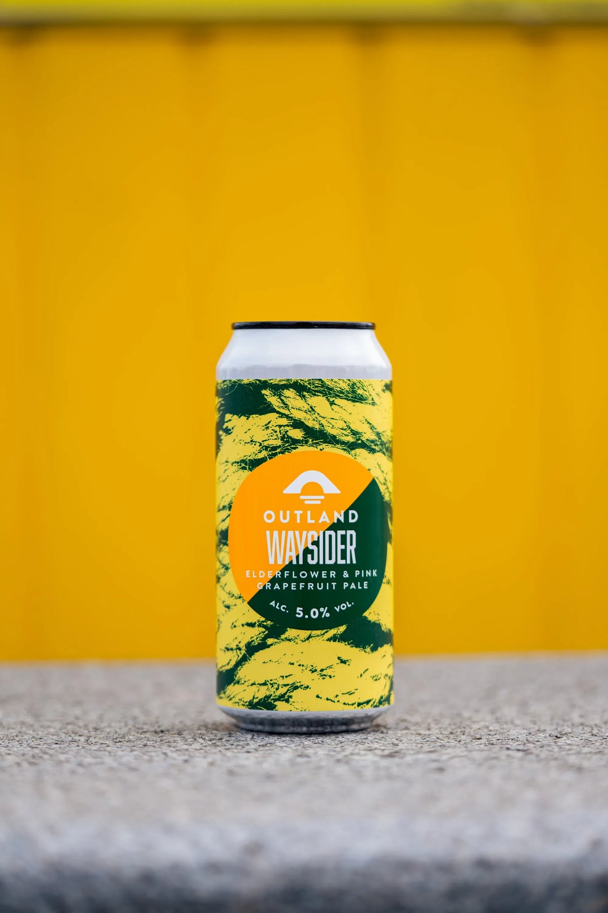 Can of Outland Waysider on a concrete ledge against a bright yellow wall