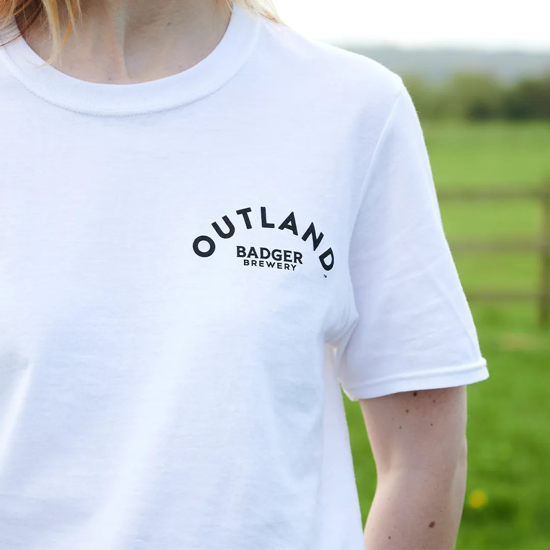 Close-up of the Outland Badger Brewery logo on the chest of the white t-shirt