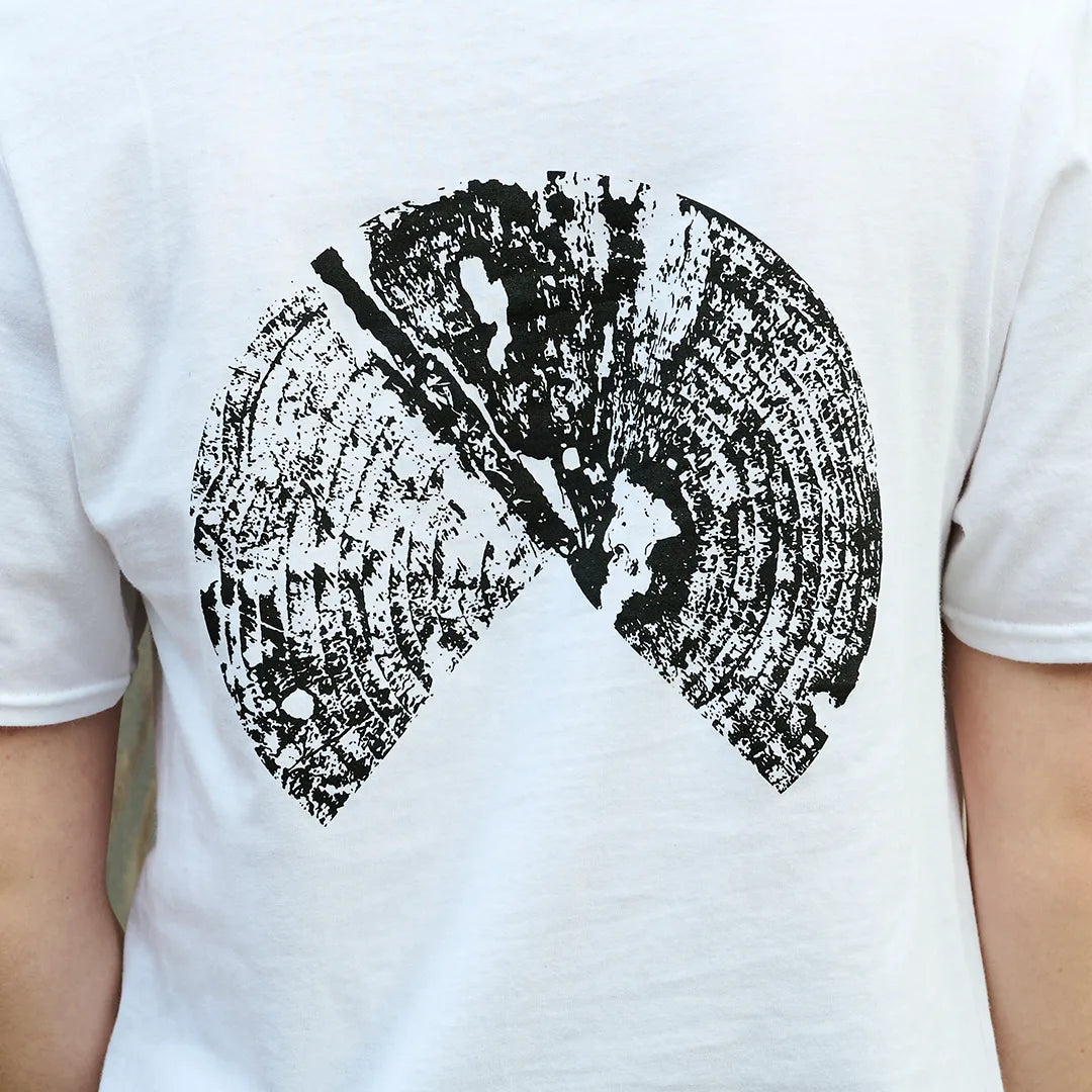 Close-up of the black tree ring graphic printed on the back of the white Outland t-shirt
