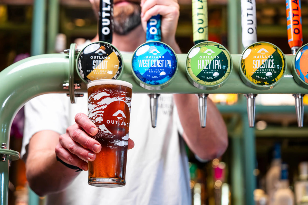 Bartender pulling a pint from the Outland keg taps