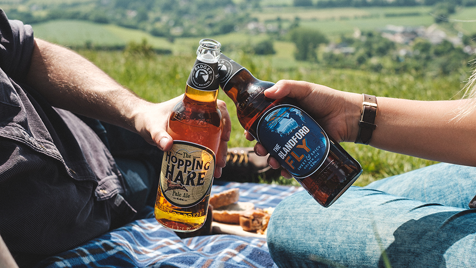 Friends enjoying award winning bottled beers Hopping Hare and Blandford Fly in the countryside