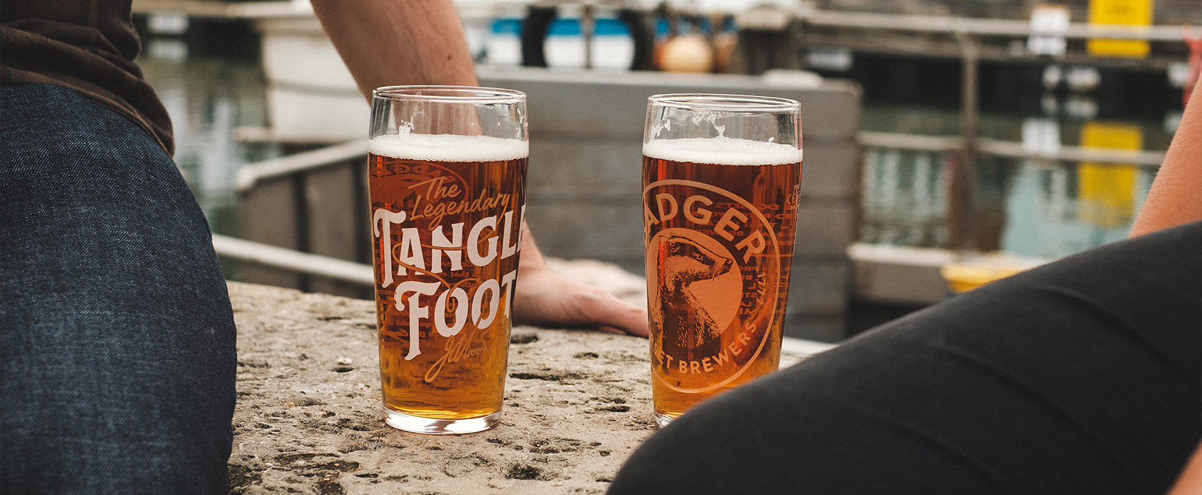 Friends enjoying pints of Badger beer in Badger Brewery beer glasses at a beer festival