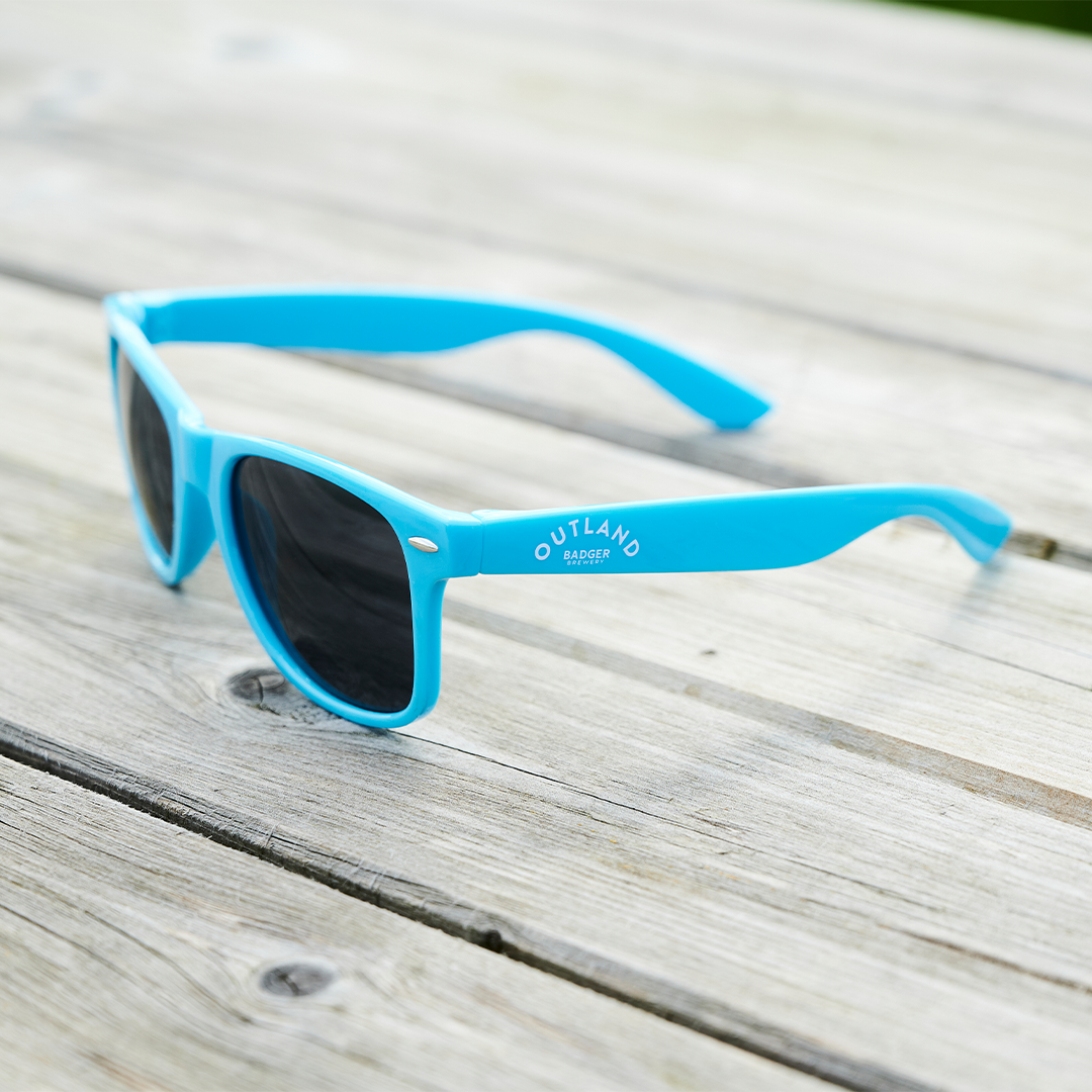 Outland Blue Sunglasses on table (side)