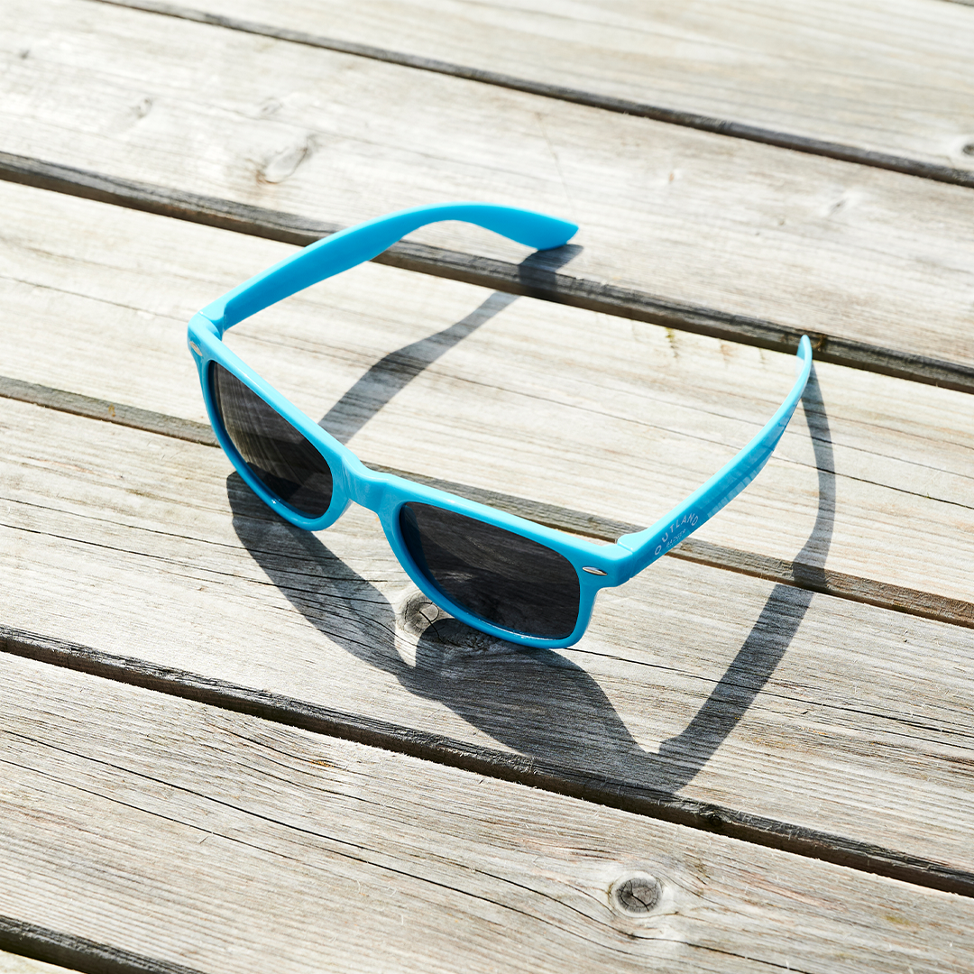 Outland Blue Sunglasses on table (side)