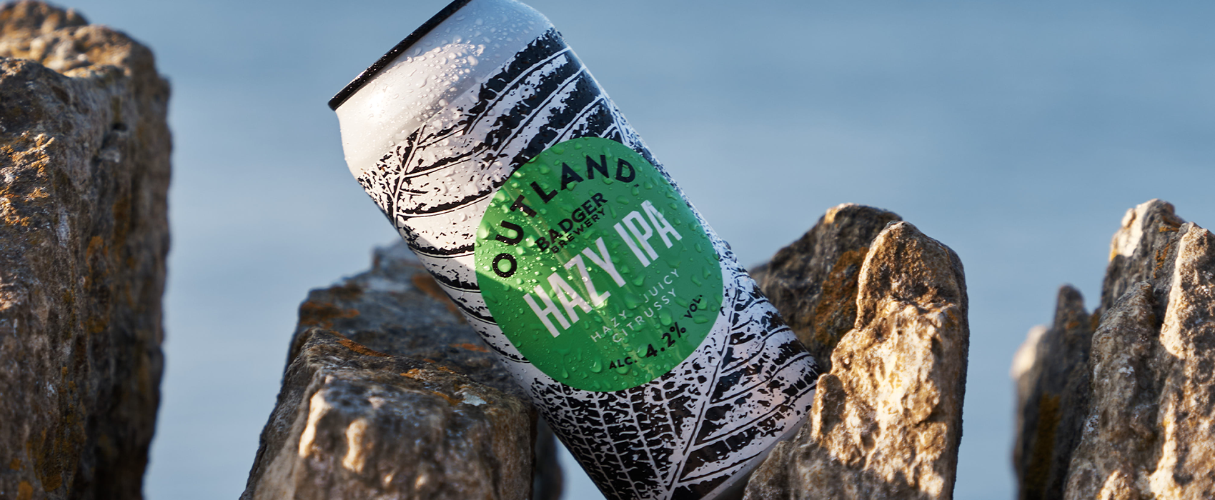 Outland Hazy IPA outside by beach