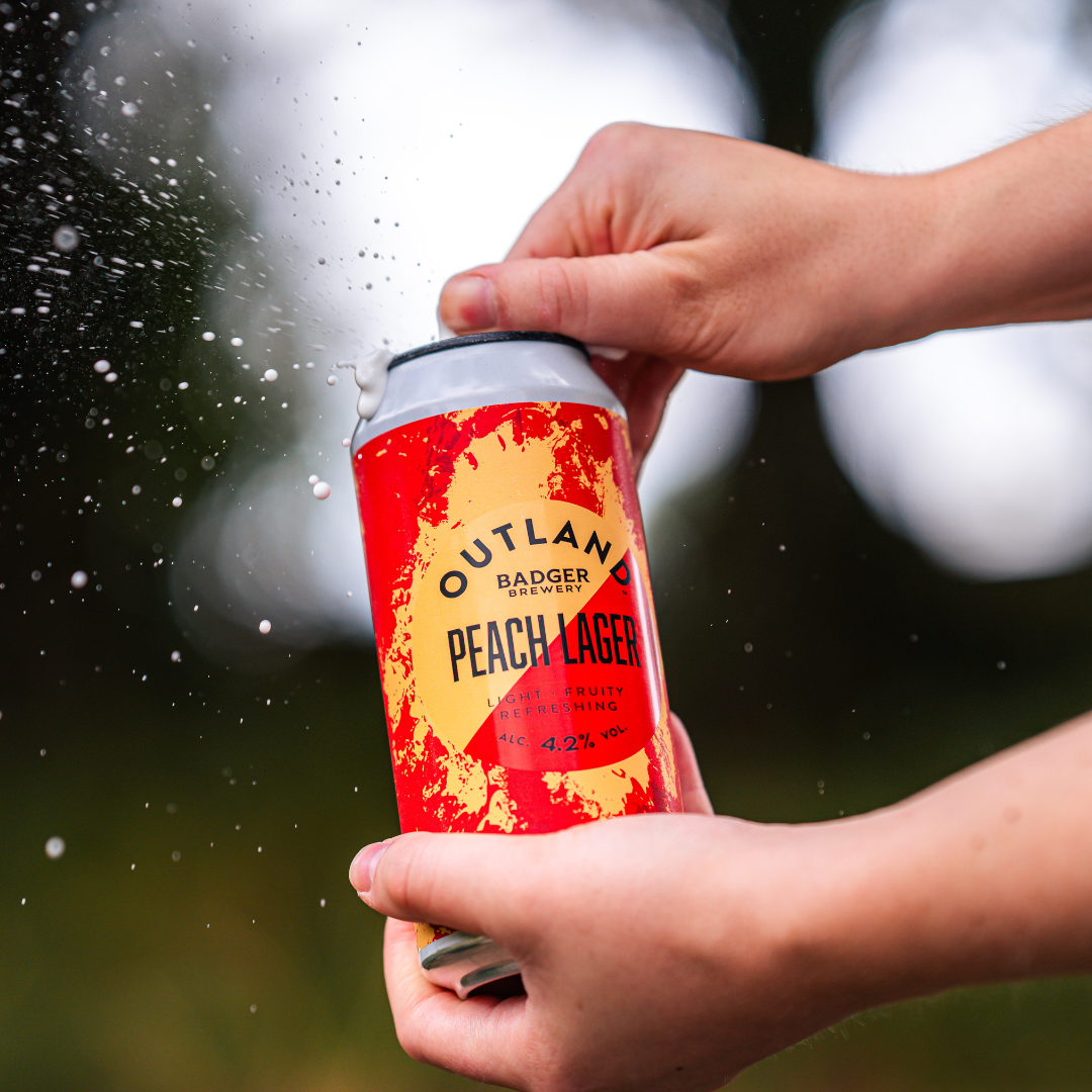 Opening can of Outland Peach Lager
