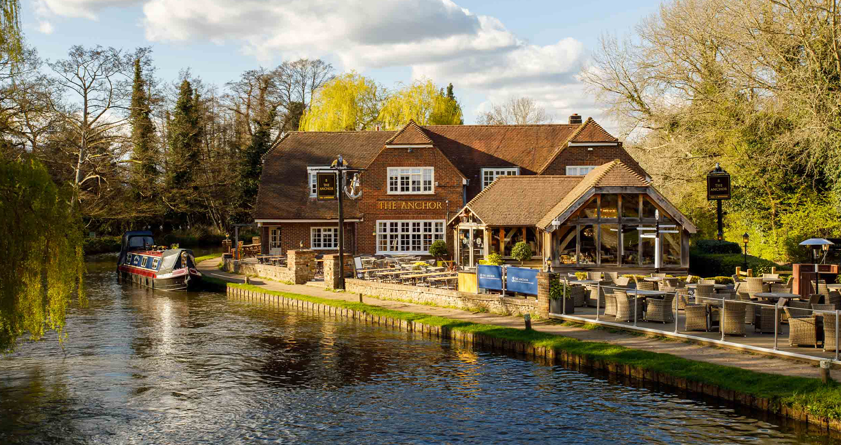 The Anchor, Hall and Woodhouse pub on the bank of the River Wey